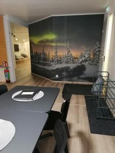 Zimmer mit einem Tisch, Stühlen und einer Wand in der Unterkunft Hostel Tikka in Rovaniemi