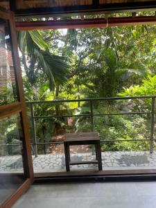 a wooden bench sitting on a balcony with trees at Jardin d'Ulysse & Hard Rock in Morjim