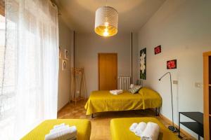 um quarto com uma cama amarela e duas cadeiras amarelas em Central Perk - NEW @ Brescia em Brescia
