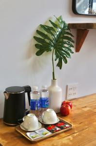 uma mesa com um vaso de plantas e um vaso sobre uma mesa em MIDMOST CASA em Can Tho