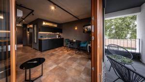 a kitchen and a living room with tables and chairs at Stadthaus Neckarsulm serviced apartments - Stadthaus Heiner in Neckarsulm