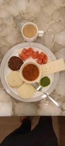 ein Teller mit Lebensmitteln auf einem Tisch mit einem Teller Lebensmittel in der Unterkunft Iconic Stay Delhi Airport in Neu-Delhi