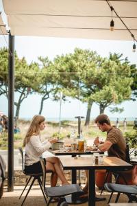 a man and a woman sitting at a table at Sauvage in Quiberon