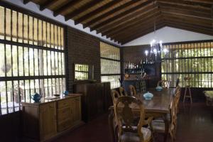 uma sala de jantar com uma mesa e algumas janelas em Casa Campestre con piscina em Guadalajara de Buga