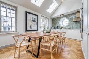 uma cozinha com uma mesa de madeira e cadeiras em ALTIDO Luxury flats near Big Ben and London Eye em Londres