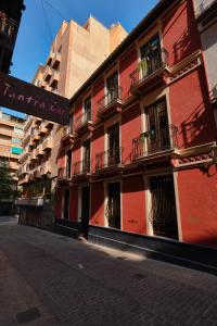 a red building with balconies on a city street at Casa Vestali in Granada