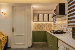 a kitchen with green cabinets and a white door at Apartment Santa Terra in Candolim