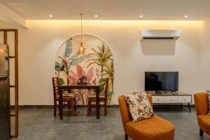 a living room with a table and chairs and a tv at Apartment Santa Terra in Candolim