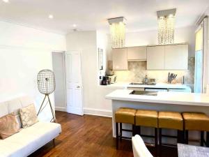 una cucina e un soggiorno con un divano e un tavolo di EMMANUEL HOUSE LOVELY 1 - BEDROOM APT IN HISTORICAL BUILDING CENTRAL CAMBRIDGE a Cambridge