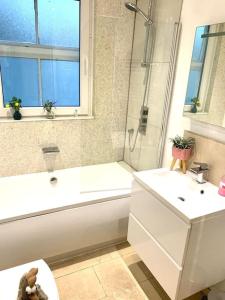 劍橋的住宿－EMMANUEL HOUSE LOVELY 1 - BEDROOM APT IN HISTORICAL BUILDING CENTRAL CAMBRIDGE，带浴缸、盥洗盆和卫生间的浴室