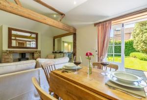 a dining room and living room with a table and chairs at Hope Cottage - West Sussex in Henfield