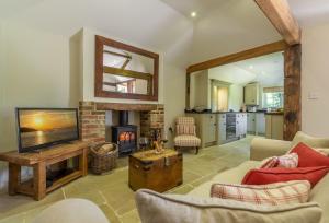 a living room with a fireplace and a television at Hope Cottage - West Sussex in Henfield