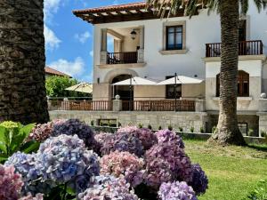 庫迪列羅的住宿－Hotel El Rosal de Cudillero，前面有鲜花的房子