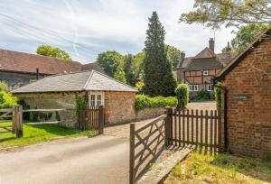 an entrance to a brick house with a wooden fence at Hope Cottage - West Sussex in Henfield