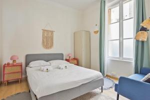 ein Schlafzimmer mit einem weißen Bett und einem blauen Stuhl in der Unterkunft Nice T4 in the 16th - Paris - Welkeys in Paris