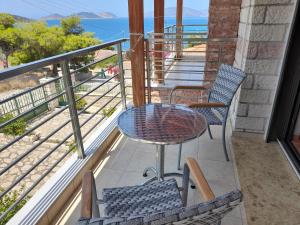 a balcony with a table and chairs and the ocean at Stone Villa at Alyki Beach in Alikí