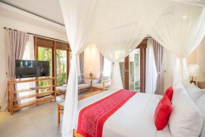 a bedroom with a white bed with a canopy at Prabhu Ubud Villa in Ubud