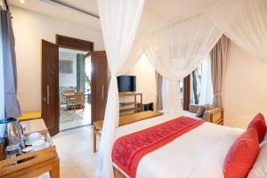 a bedroom with a white bed with a canopy at Prabhu Ubud Villa in Ubud