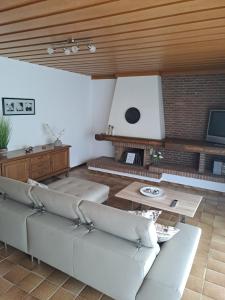 a living room with white couches and a fireplace at In der Heide in Löhne