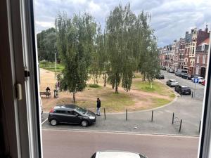 uma vista de uma janela de uma rua com um carro em studio très agréable em Roubaix