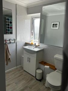 y baño con lavabo, aseo y espejo. en Sheringham, Norfolk - Seaside Retreat - 15 min walk to beach, en Sheringham