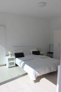 una camera con un letto e una parete bianca di Residenz La Gerbia a Cannobio