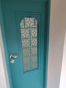 a blue door with a window on it at Emilie Guest House in Haifa
