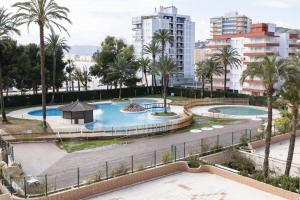 a view of two pools with palm trees and buildings at Florazar 2, Iv-14-C in Cullera