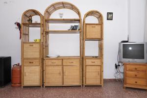 a wooden bookcase with three shelves and a tv at Florazar 2, Iv-14-C in Cullera