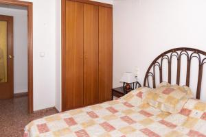 a bedroom with a bed and a wooden closet at Florazar 2, Iv-14-C in Cullera +21 photos