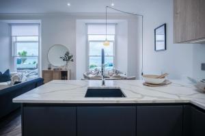 uma cozinha com um lavatório e um balcão em No 4 Croft House - Luxury 2 Bed Apartment - Tenby em Tenby