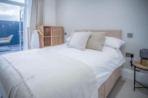 um quarto com uma grande cama branca e uma varanda em No 4 Croft House - Luxury 2 Bed Apartment - Tenby em Tenby