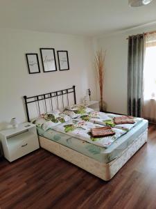 1 dormitorio con 1 cama grande y suelo de madera en No°21 Apartman, en Szilvásvárad