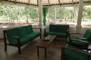 a living room with green chairs and a table at Green Nest Yala in Hambantota