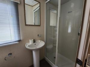 a bathroom with a sink and a shower at D&A's Short Breaks - St Margarets Bay, Dover in St Margarets at Cliff