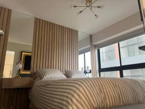 1 dormitorio con cama y ventana grande en Estreno Depa frente CC El polo, en Lima