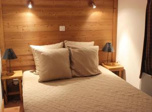 a bedroom with a bed with two lamps on tables at Eskival Appartements VTI in Val Thorens