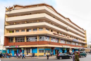 um edifício com pessoas a andar na frente dele em Mang City Hotel em Nairobi