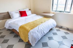 um quarto com uma cama com uma almofada vermelha em Mang City Hotel em Nairobi