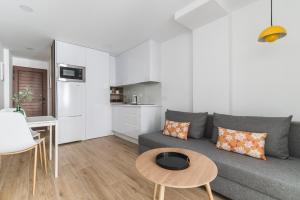 Sala de estar con sofá gris y mesa en Home2Book Stylish Apartment Playa del Inglés, en Maspalomas