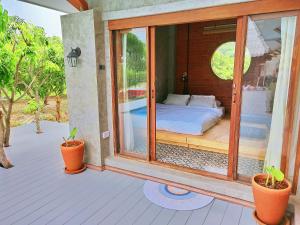 a room with a bed on a porch with plants at Greyhouse Homestay 