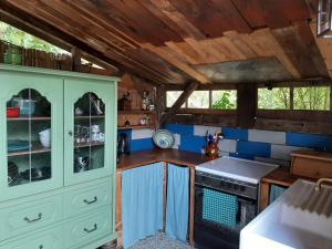 a kitchen with blue walls and wooden ceilings at la ruche in Grospierres