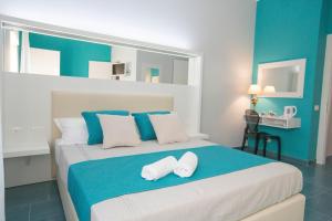 a blue and white bedroom with a bed with two white towels at B&b Olas Del Mar in Cefal&ugrave;