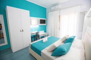 Schlafzimmer mit blauen Wänden und einem Bett mit Kissen in der Unterkunft B&b Olas Del Mar in Cefalú