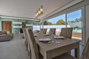 a dining room with a wooden table and chairs at Villa Blu - Family Villa with Indoor heated Pool, Sauna and Games Room in Mellieħa