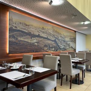 a restaurant with tables and chairs and a painting on the wall at Hotel DAP in Prague
