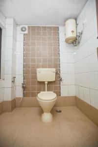 a bathroom with a toilet and a shower stall at Hotel Maneck Residency in Ooty