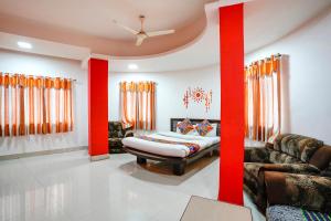 a living room with a bed and a couch at FabExpress Sai Lodging in Nashik