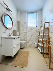 a bathroom with a toilet and a sink and a mirror at Apartmány Kamenec in Zákamenné