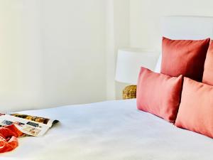 uma cama com almofadas vermelhas e uma revista em Canaryislandshost l Room em Playa Blanca